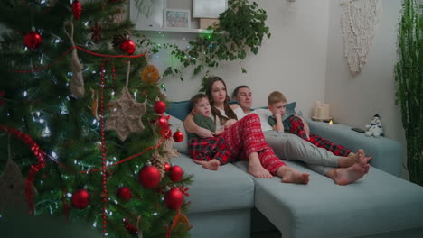 Familienzusammenhalt-Zu-Weihnachten.-In-Den-Weihnachtsferien-Gemeinsam-Auf-Dem-Sofa-Sitzen-Und-Zu-Hause-Fernsehen.-Hochwertiges-4K-Filmmaterial